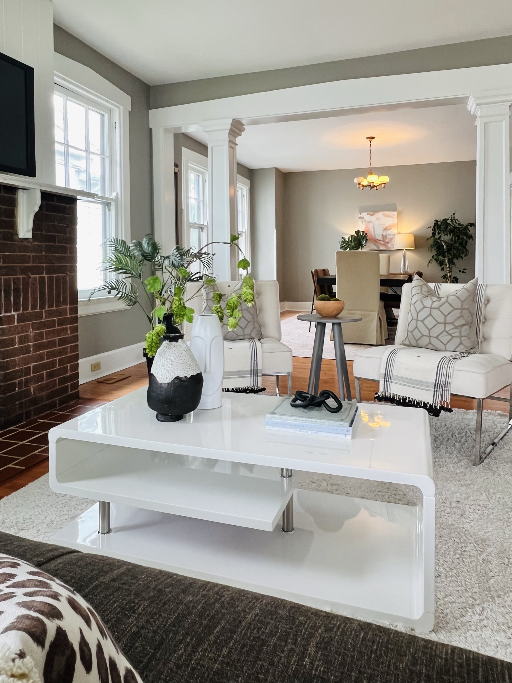 Sitting room with fireplace, white trim, and dining room beyond